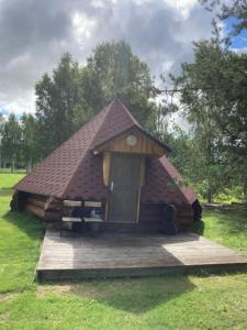 eine kleine Hütte mit einem Dach im Gras in der Unterkunft Kakulaane Tourism Farm in Lauküla