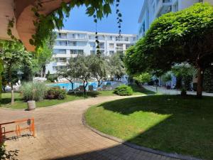 een park met een bank en een gebouw bij Central, 1 Bed Apt, 3* Yassen in Sunny Beach