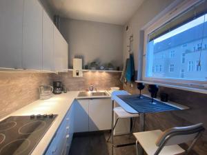 cocina con fregadero y mesa con ventana en Cozy Modern Apartment with Small Balcony in the Heart of Berlin en Berlín