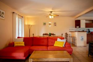 un soggiorno con un divano rosso e un tavolo di Avalon a Grospierres Altre 6 foto