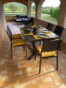 una sala da pranzo con tavolo e sedie su un patio di Avalon a Grospierres