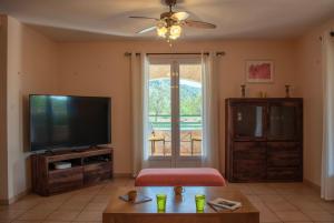 un soggiorno con TV a schermo piatto e tavolo di Avalon a Grospierres