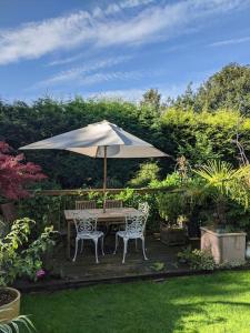 a table and chairs under an umbrella in a garden at Appletree House 