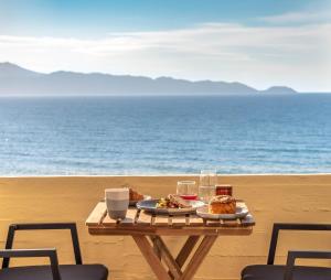 a table with two plates of food on the beach at Mare Blue Bliss with SeaView by 8essentially in Heraklio
