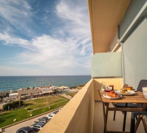 a balcony with a table and a view of the ocean at Mare Blue Bliss with SeaView by 8essentially in Heraklio