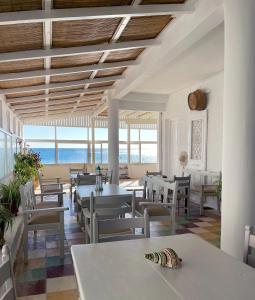 a restaurant with tables and chairs and a view of the ocean at Vista Mare in Koutsourás