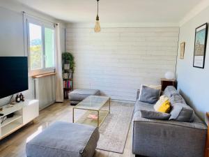 ein Wohnzimmer mit einem Sofa und einem TV in der Unterkunft Superbe appartement 2 chambres, clim, quartier calme entre la mer et les calanques in Marseille