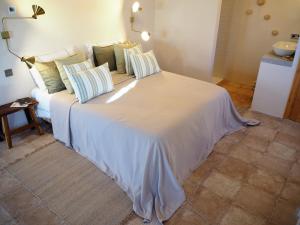 a large white bed with pillows on it in a room at Casa Amandava in Salobreña