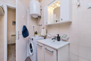 baño blanco con lavadora y lavamanos en Cappelli Apartments - Lošinj en Mali Lošinj