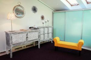 een kamer met een dressoir en een gele stoel bij Ancora in Rijeka