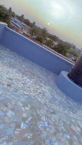 una piscina con una pared azul y rocas en el suelo en Emefa Room, en Cotonou