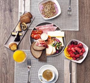 a table with plates of food on a table at Hotel Ankaa - Adults Only in Porto Cristo