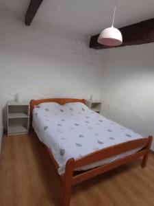 1 dormitorio con 1 cama con sábanas blancas y lámpara en La Tranquillite, La Serenite, en Nanteuil-de-Bourzac