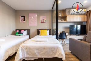 a bedroom with two beds and a tv and a couch at BTS S5 Surasak900米 近湄南河码头 ·摩天轮夜市 免费游泳池·中文接待·曼谷中心 in Ban Khlong Prawet