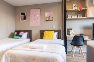 a bedroom with two beds and a chair at BTS S5 Surasak900米 近湄南河码头 ·摩天轮夜市 免费游泳池·中文接待·曼谷中心 in Ban Khlong Prawet