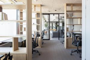 een open kantoor met bureaus, stoelen en tafels bij Noli Herttoniemi in Helsinki