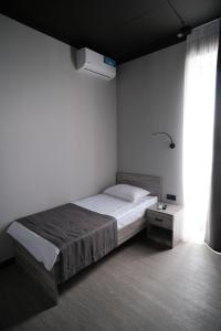 Vip Avtim hotel في أوجهورود: غرفة نوم بيضاء مع سرير وموقف ليلي
