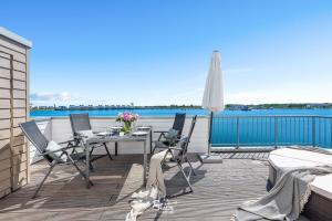 a table and chairs on a deck with a view of the water at Port 55 in Olpenitz