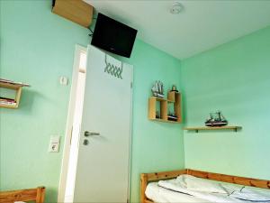 Schlafzimmer mit einem Bett und einem TV an der Decke in der Unterkunft Vier Jahreszeiten 4-7 in Großenbrode