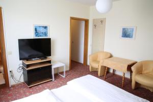 a hotel room with a bed and a flat screen tv at Hotel Reinisch in Köflach