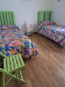dwa łóżka i krzesło w pokoju w obiekcie casa S Leonardo w mieście Crotone