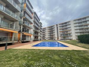 um edifício de apartamentos com uma piscina num quintal em Les Marines em Roses