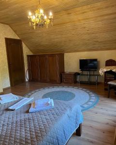 ein Schlafzimmer mit einem großen Bett und einem Kronleuchter in der Unterkunft Вiлла Тераса in Poljana
