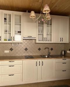 a kitchen with white cabinets and a sink at Вiлла Тераса in Polyana