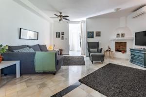Una sala de estar con un sofá y un televisor. en Casa Karma, en Mijas
