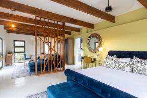 a bedroom with a blue bed and a living room at Oase by 7 Star Lodges - Greater Kruger Private 530ha Reserve in Hoedspruit