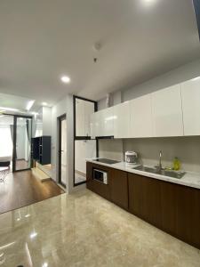 Asahi Luxstay - Green Pearl Bắc Ninh Serviced Apartment في Hòa Ðình: مطبخ كبير مع دواليب بيضاء ومغسلة