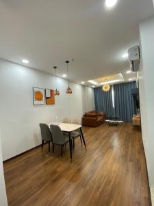 a dining room and living room with a table and chairs at Asahi Luxstay - Green Pearl Bắc Ninh Serviced Apartment in Hòa Ðình