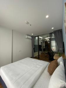 sypialnia z dużym białym łóżkiem w pokoju w obiekcie Asahi Luxstay - Green Pearl Bắc Ninh Serviced Apartment w mieście Hòa Ðình
