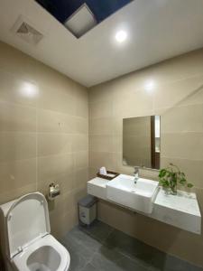y baño con lavabo, aseo y espejo. en Asahi Luxstay - Green Pearl Bắc Ninh Serviced Apartment, en Hòa Ðình