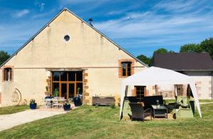 a barn with a tent and chairs in front of it at Bulle Elevage Girbal in La Chapelotte