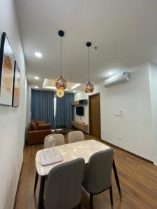 Asahi Luxstay - Green Pearl Bắc Ninh Serviced Apartment في Hòa Ðình: غرفة معيشة مع طاولة وكراسي بيضاء