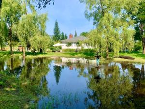 ein Haus mit einem Teich vor einem Haus in der Unterkunft Lake House Family in Wiewiecko