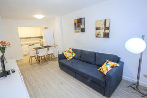 sala de estar con sofá azul y cocina en Grekus Litoral - ONLY FAMILIES, en Cambrils