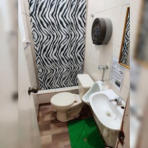 a bathroom with a toilet and a sink and a zebra print door at Antis Cusco in Cusco