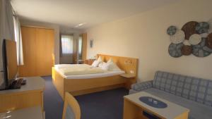 a hotel room with a bed and a couch at Landhotel Larenzen in Kirchham