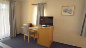 a hotel room with a desk with a tv and a desk sidx sidx at Landhotel Larenzen in Kirchham