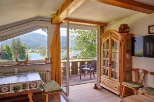 a room with a balcony with a view of a lake at Ferienwohnungen Landhaus Gerum in St. Wolfgang