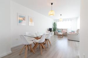 a white living room with a table and chairs at Global Properties, Moderno apartamento a 3 minutos de la playa in Puerto de Sagunto