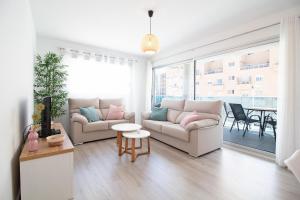 a living room with two couches and a table at Global Properties, Moderno apartamento a 3 minutos de la playa in Puerto de Sagunto