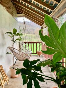 a porch with a swing and plants on a deck at Aburry, maison poétique à la montagne in Barcus
