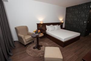 a hotel room with a bed and a chair at Hotel Sky Gevgelija in Gevgelija