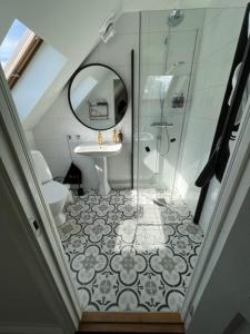 y baño con ducha, lavabo y espejo. en Rörums Gårdshotell, en Simrishamn