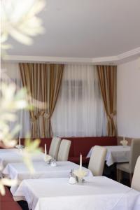 a dining room with white tables and white chairs at Pension Kleon in Rifiano