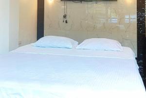 a large white bed with two pillows on it at KrizLion Hotel in Hinatuan