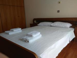 een slaapkamer met een bed met handdoeken erop bij Village Apartment 